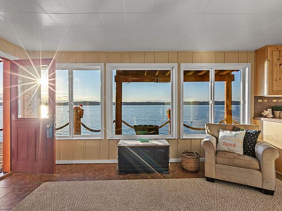 Living room with full views of Puget Sound and the Olympic Mountains. A cozy free-standing wood stove (not pictured) opposite the living room windows.