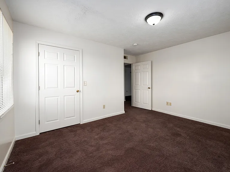 Peaceful bedrooms feature neutral walls and comfortable carpeting for restful living, professionally operated by Highlands Vista Group.