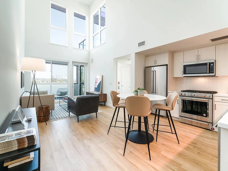 Loft-style home with soaring ceilings, oversized windows, and an open kitchen that fills the space with natural light and expansive views.