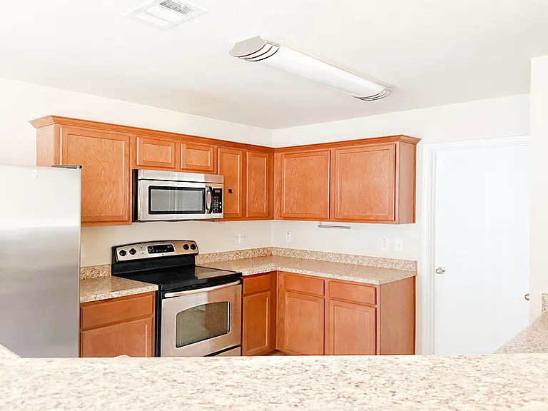 Great kitchen with stainless steel stove, microwave, refrigerator & loads of cabinets.