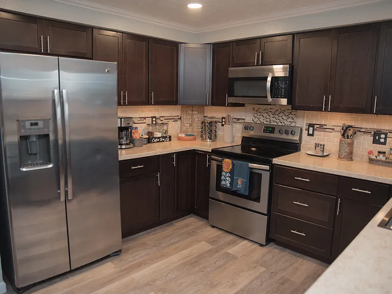 Fully equipped kitchen with modern stainless steel appliances and sleek dark cabinetry.