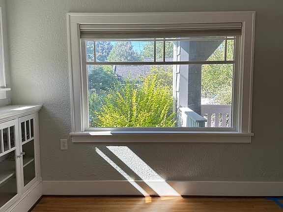 Picture windows facing street, large shrubbery for privacy.