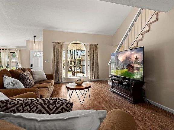 A beautiful floor-to-ceiling arched window draws in natural light highlighting the natural tones in the home.