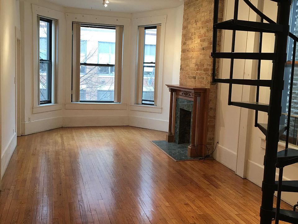 living room with decorative fireplace, staircase to roof deck and adjustable track lights for your art work