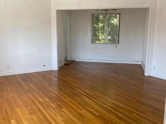 View of living space, hard wood floors, and dinning space with window.