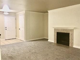 Alternate view of living room shows the front door and door to large laundry room.