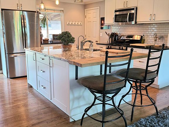 Remodeled kitchen with stainless steel appliances and large granite center island.