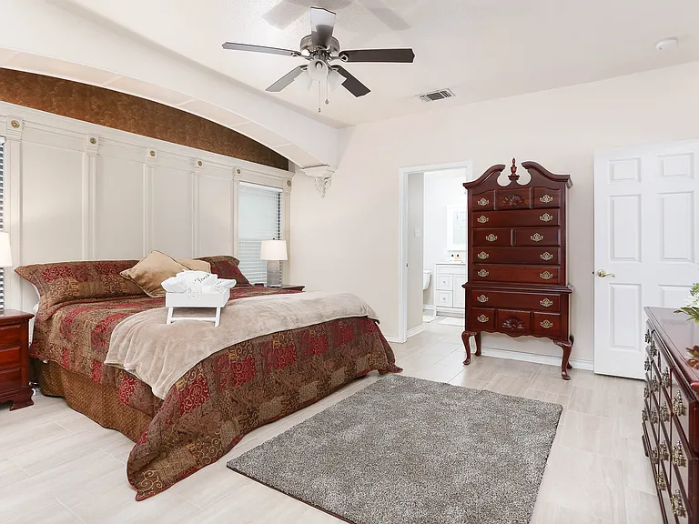 Huge primary bedroom on main floor with a king size Sleep Number bed. Decorative wall details and lighting. Ceiling fan.