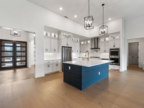 The kitchen has gorgeous white cabinetry with black hardware.