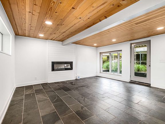 shiplap accent electric fireplace and recessed lighting throughout