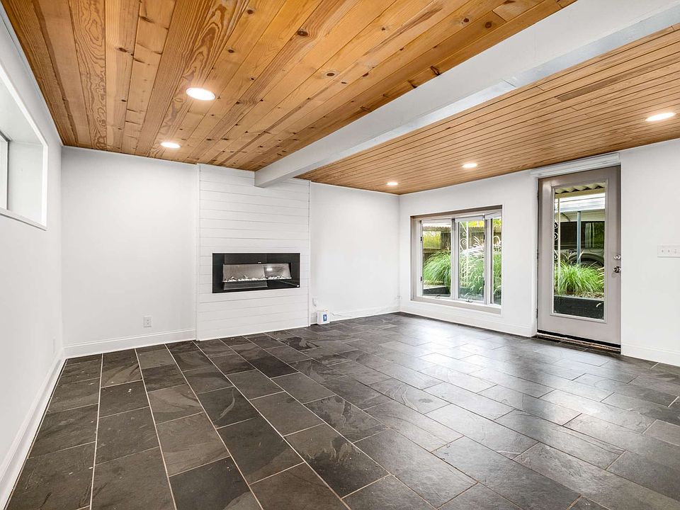 shiplap accent electric fireplace and recessed lighting throughout