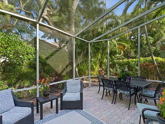 the lanai with six place lunch or dinner table with lounge chairs