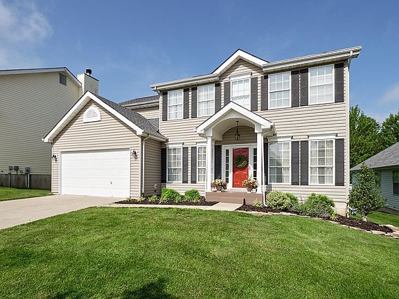 Great landscaping, pretty front porch and door with side lights.