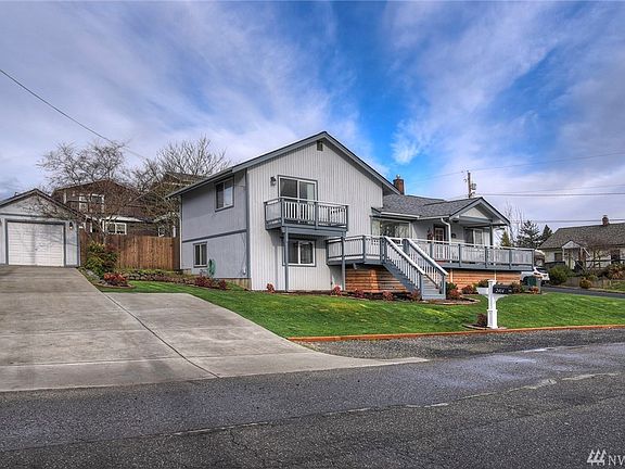 Newer concrete driveway done within last 5 years, leads to detached 1-car garage. Carport attached around the other side