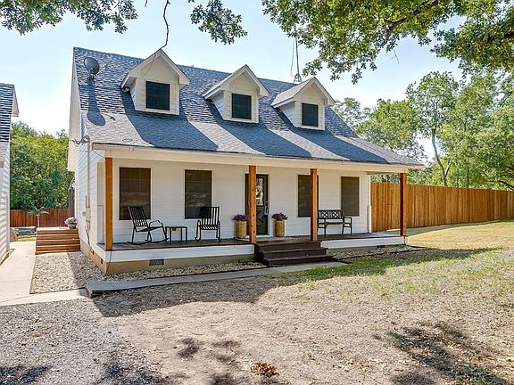 Rear view of property featuring crawl space, a shingled roof, and a porch