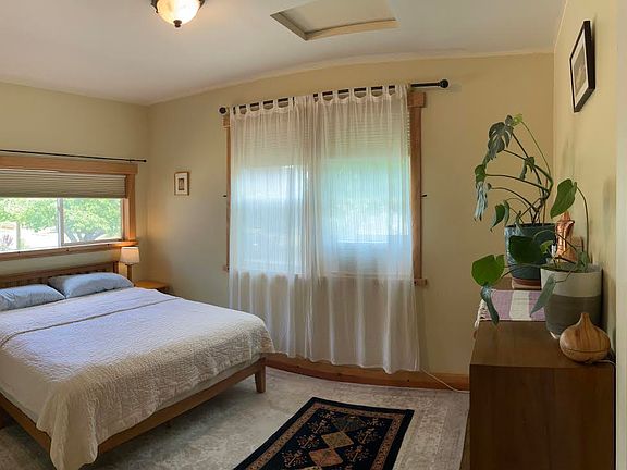 Primary bedroom w/ two large windows.