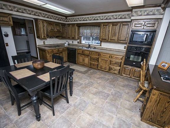 Kitchen has plenty of beautiful custom cabinets for storage including a built in matching desk that divides the kitchen and living room. Kitchen also has new laminate flooring and countertops with electric cooktop.