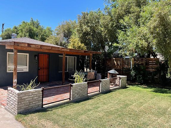 Front yard and patio area with seating.