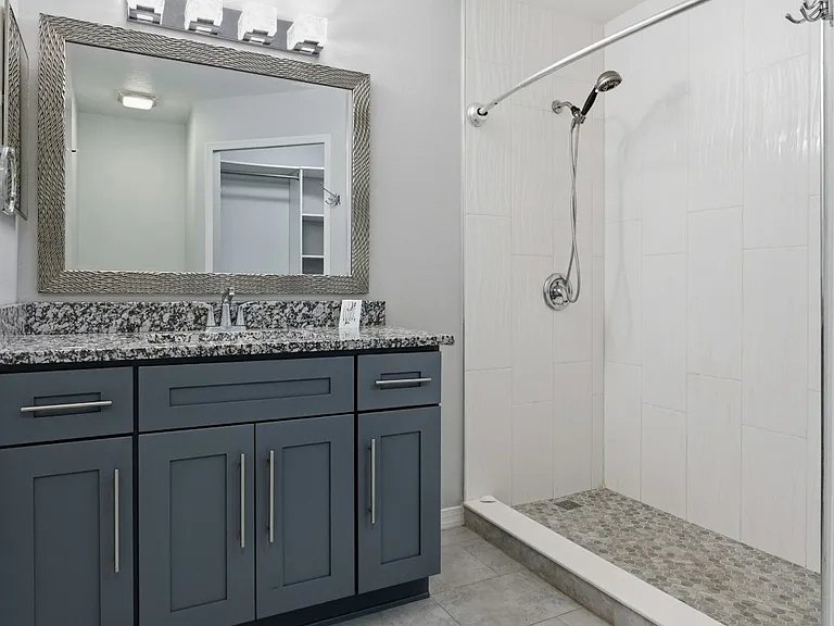 Master bath with soft close vanity, granite counter top, standing shower & ventilation fan