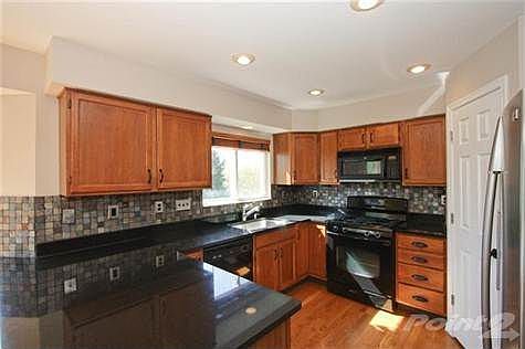 The kitchen is fully equipped with updated granite counter tops, tile backsplash, stainless fridge and warm hearty wood cabinets to go with the hardwood floors.