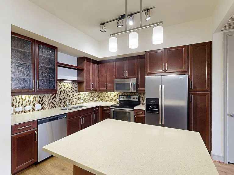 Apartment Kitchen with Quartz counter tops and Wood Style Flooring.