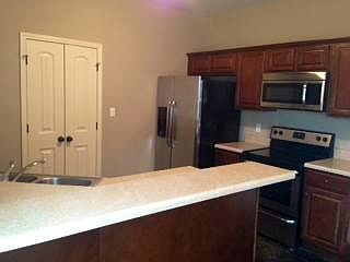 Kitchen Has Stainless Appliances Including Refrigerator