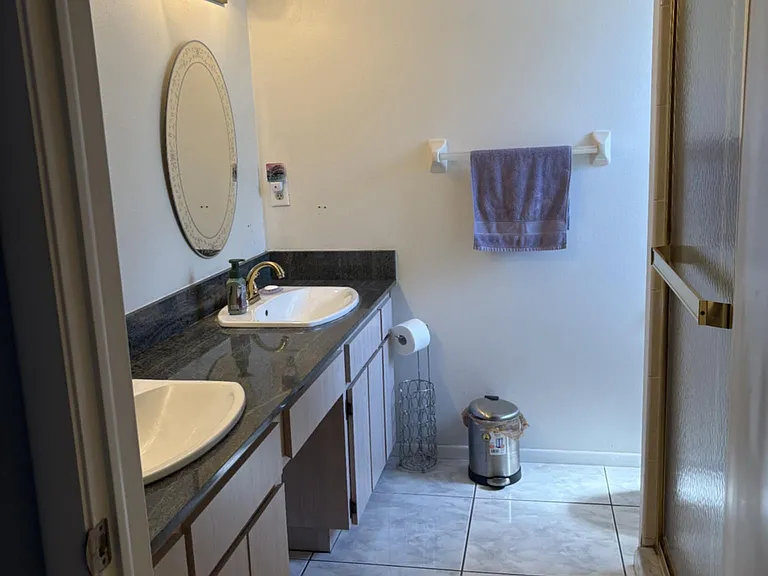 master bathroom showing his/her sinks and shower