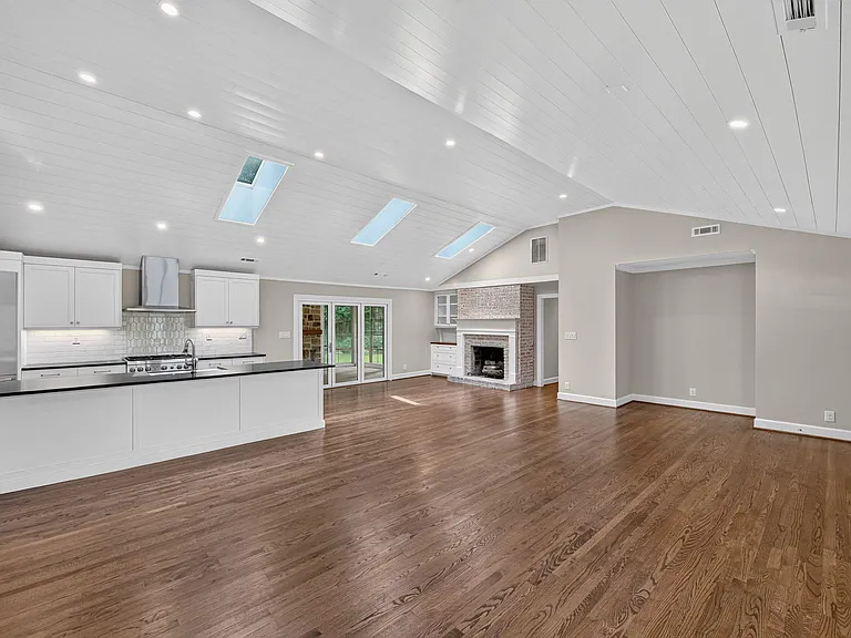 View from the family room towards the gas fireplace, the hall to the bedrooms, and the 3-season porch.