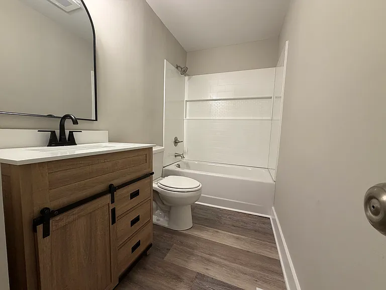 Full bath with new cabinet and tub surround.