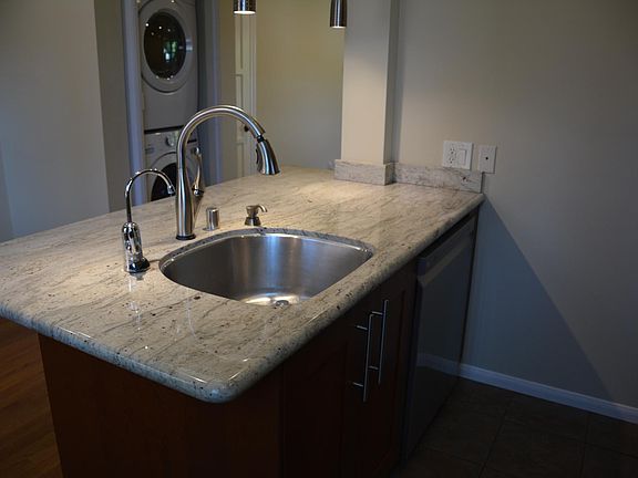 Kitchen island with dishwasher. Washer/dryer in the background