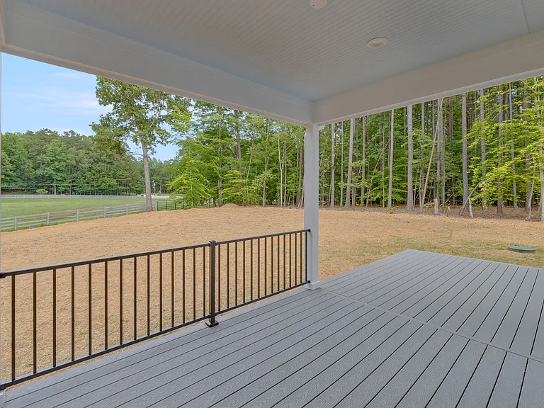 Covered rear porch overlooks the flat back yard and adjacent farm