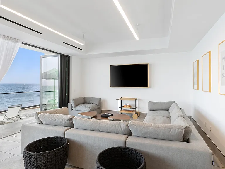 Open seating space with smart TV, overlooking the Pacific Ocean.