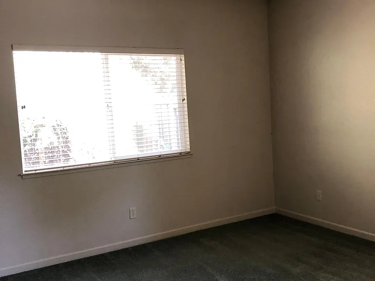 Primary bedroom has two window areas and adjoining bathroom with two mirrored double door closets.