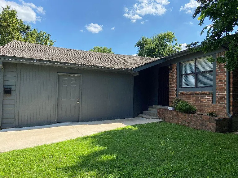Exterior side view of front and garage doors.