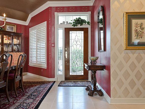 Foyer with leaded glass front door with side lights and transom, limestone tiled flooring and breathtaking views of the living areas. Other features include sconced & recessed lighting, custom faux paint and decorative archways.