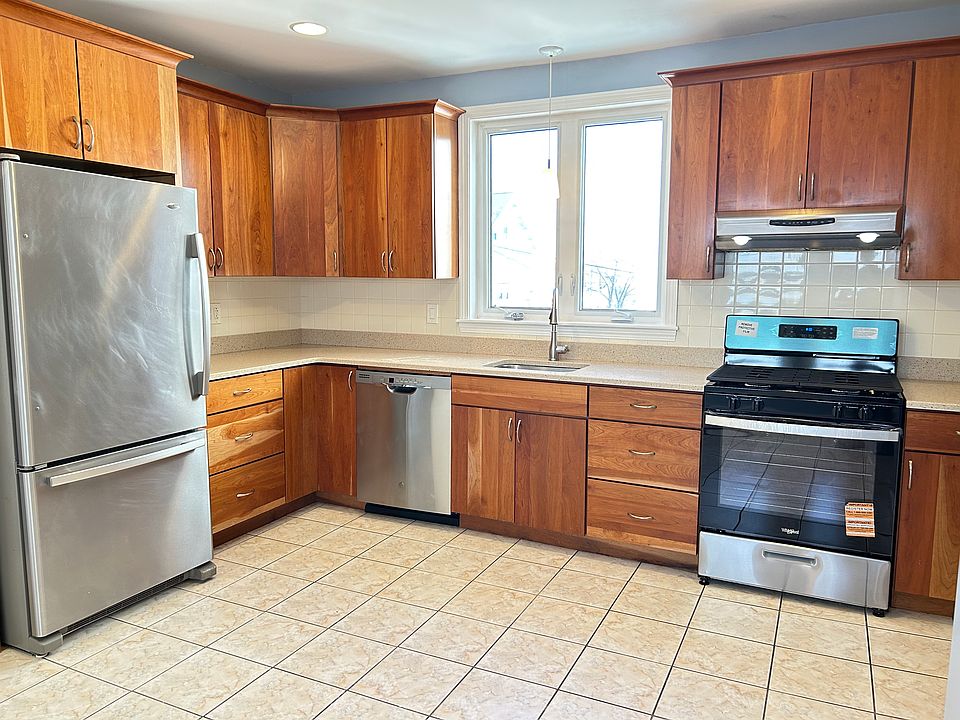 Updated kitchen with tall cherry-finish cabinets and ample counter space