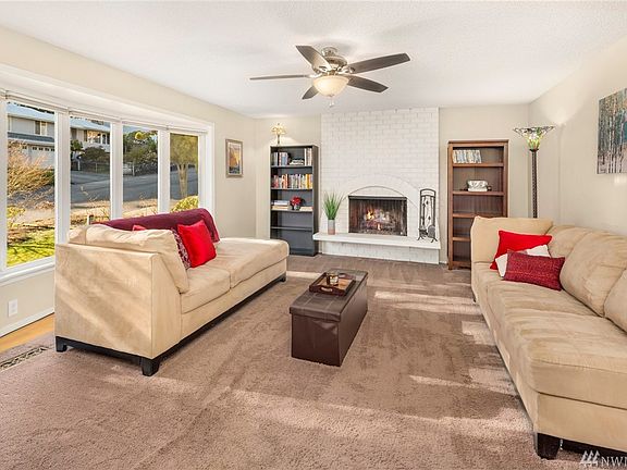 Upper level living room centered around the trendy white painted brick wood burning fireplace, soaked in natural light!