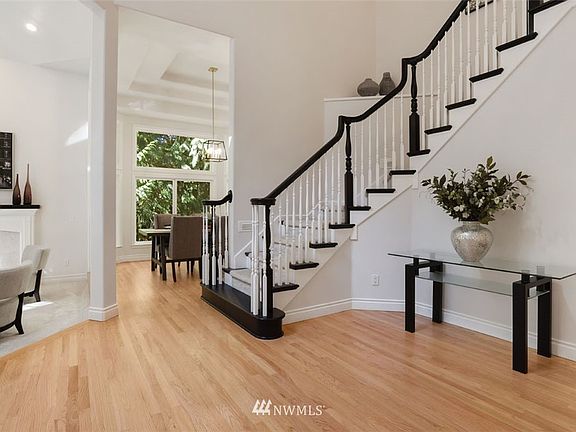 Swing open the door to find stunning entryway with soaring ceilings, amazing architectural design, warm hardwoods, and captivating staircase. 