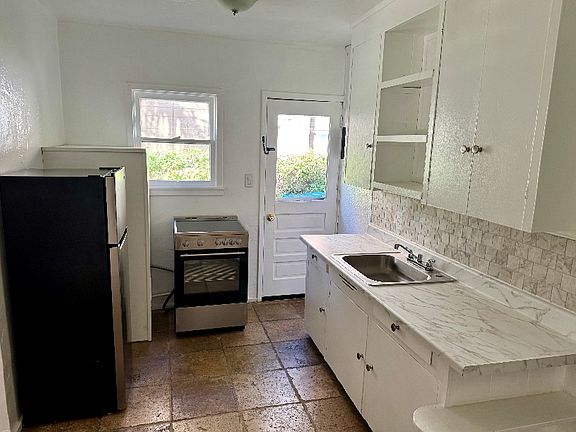 Kitchen. New appliances, sink, counter. Side door goes to driveway.