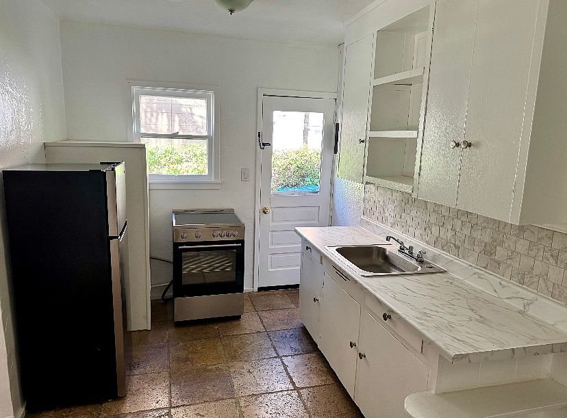 Kitchen. New appliances, sink, counter. Side door goes to driveway.