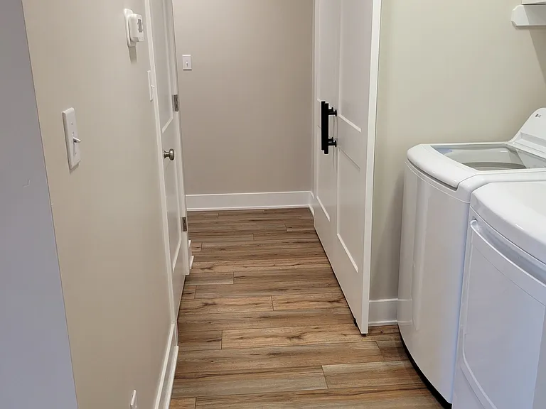 Hallway to bedrooms and full size laundry with equipment