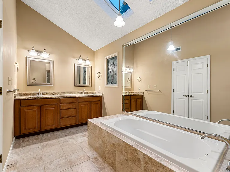 Master bathroom. Two sinks, bathtub and a shower.