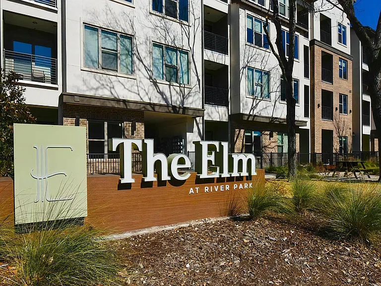 The Elm at River Park Entrance Sign in Front of Apartment Building