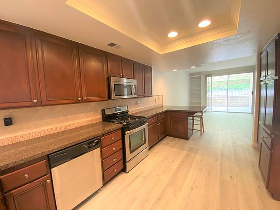 granite countertops, dishwasher, stove, and microwave