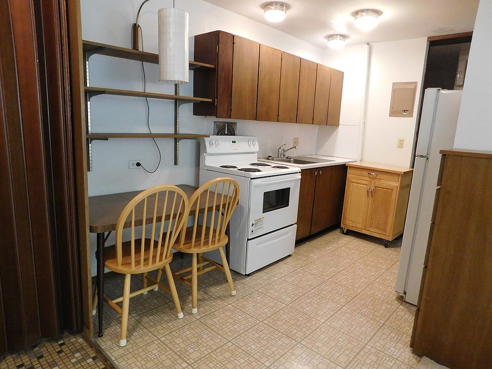 Dining area features shelving above table and a hanging lamp to conserve space. Kitchen has excellent storage in the built in cabinets and portable rolling cart which also provides more counter space. Excellent lighting in kitchen makes meal prep easy.