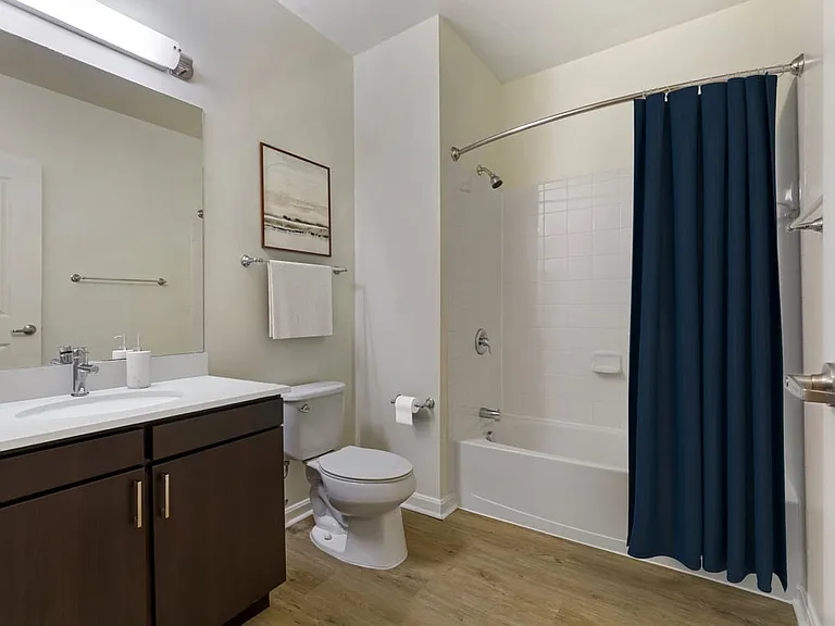 Renovated Package I bath with white quartz countertop, espresso cabinetry, and hard surface flooring