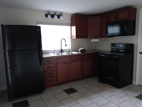 Kitchen with refrigerator, stove, and over the stove microwave oven.