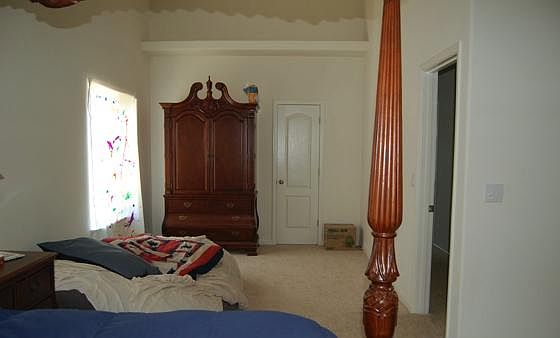 Opposite side of master bedroom with space for desk/office. Armoire pictured is 7-feet tall, 4-feet wide. The door next to it is the his-and-hers walk-in closet.