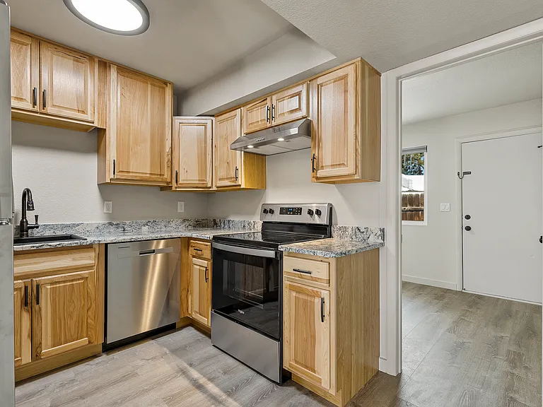 Kitchen with real wood cabinets and granite countertops finished with all stainless steel appliances.