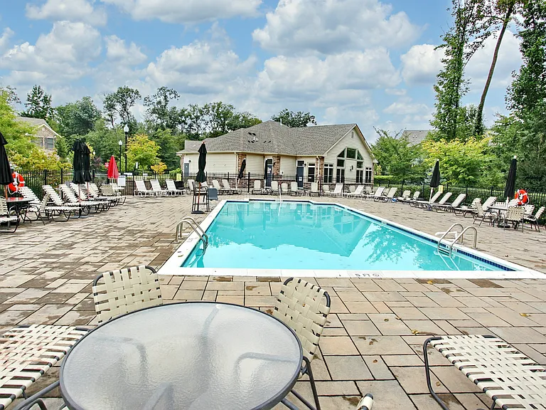 Community outdoor heated pool surrounded by beautifully maintained grounds